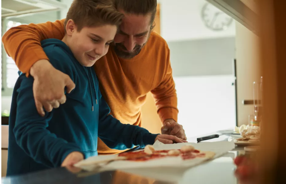 Vader knuffelt zijn zoon tijdens het koken