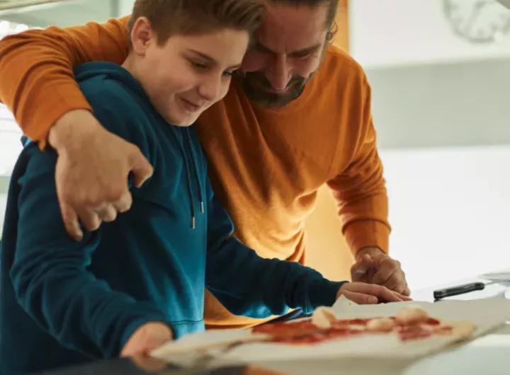 blog_dad_hugging_son_blue_hoodie_during_cooking_720x530.webp